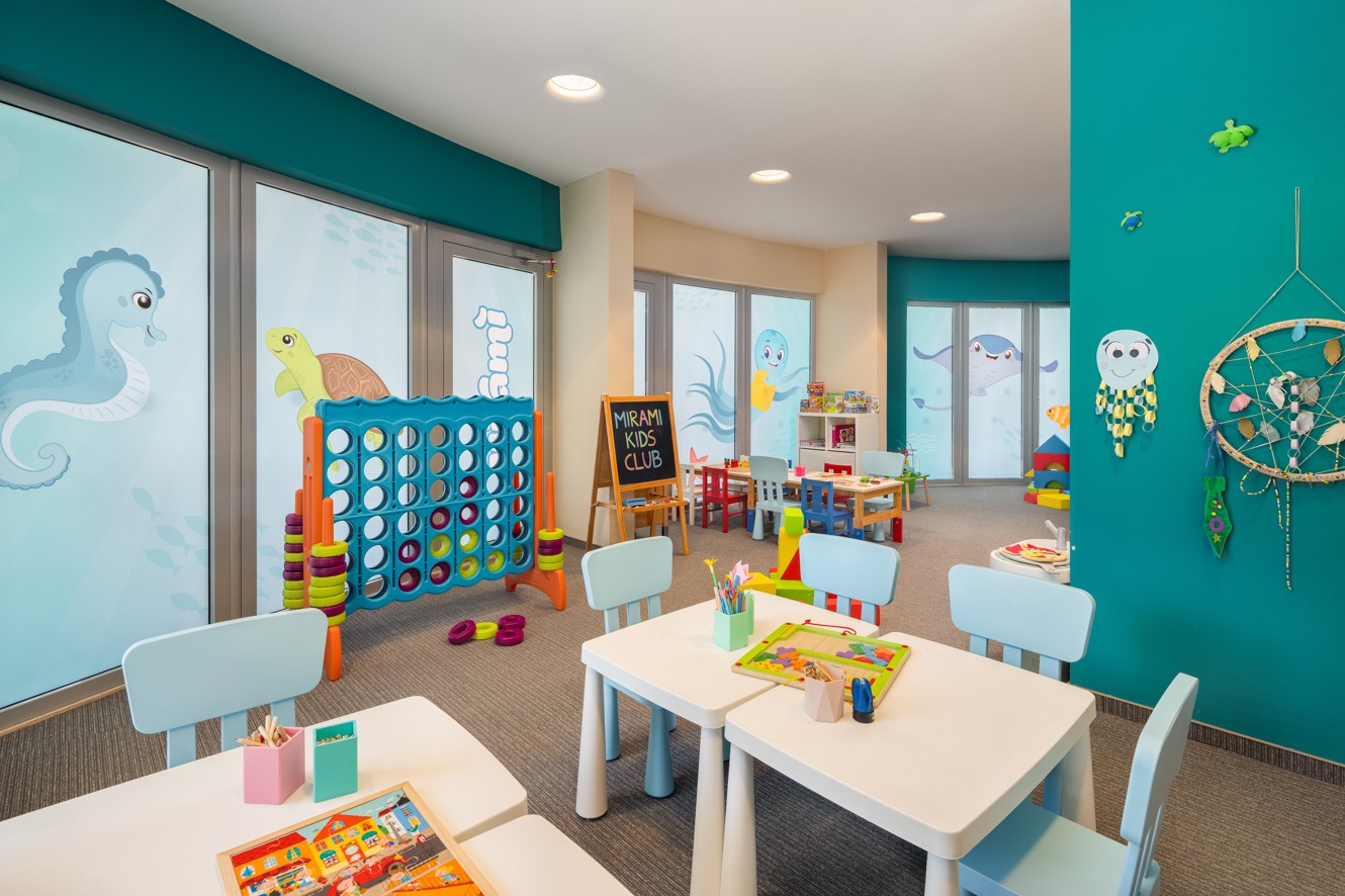 Colorful mini club playroom at Aminess Vival Grand Azur Hotel with children's tables and toys.