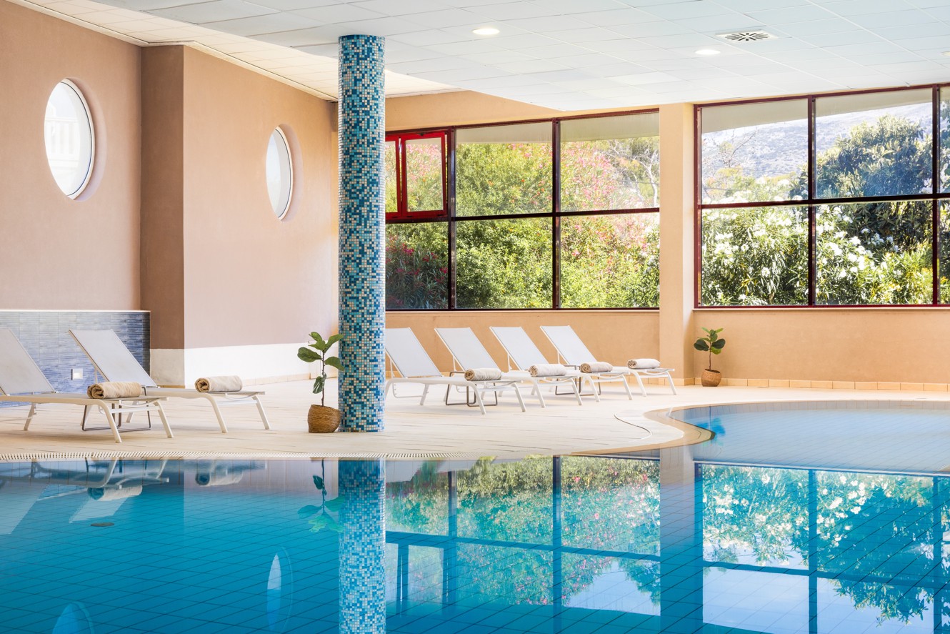 Unutarnji bazen u Maradiso Marko Polo by Aminessl na Korčuli s opuštajućom atmosferom, kaskadnim vodenim značajkama i velikim prozorima za prirodnu svjetlost.