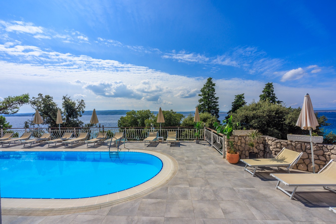 Vanjski bazen u hotelu Mediteran Maradiso by Aminess s pogledom na more i okolno zelenilo.