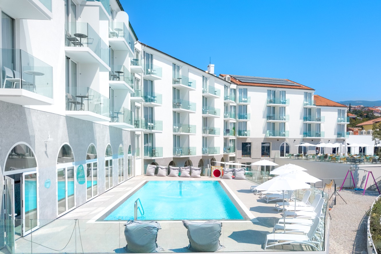 Vista lato piscina dell'Aminess Vival Lišanj Family Hotel che mette in mostra la piscina all'aperto e l'architettura moderna dell'hotel.