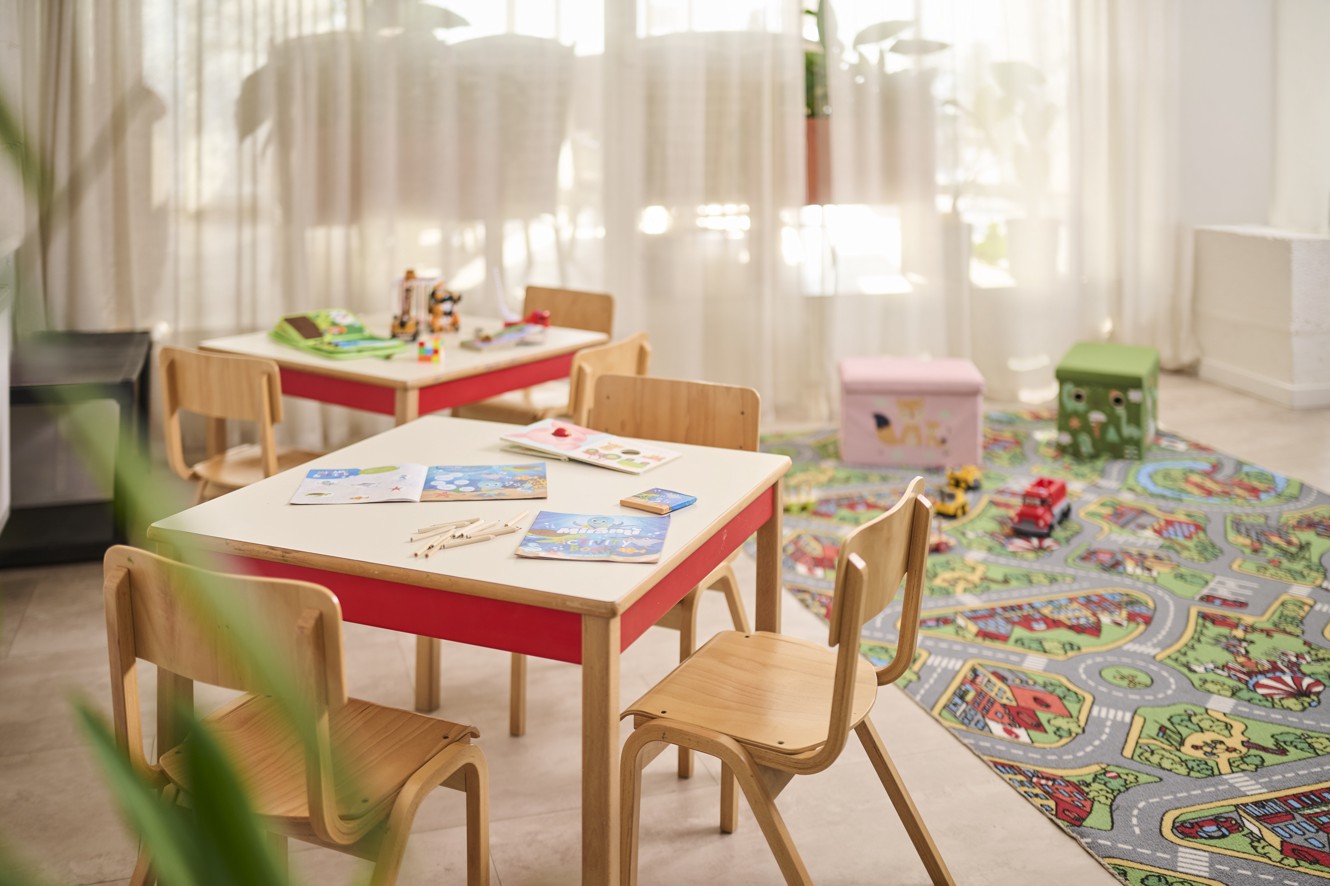 Kids corner with tables, chairs, books and toys at Aminess Maradiso Hotel