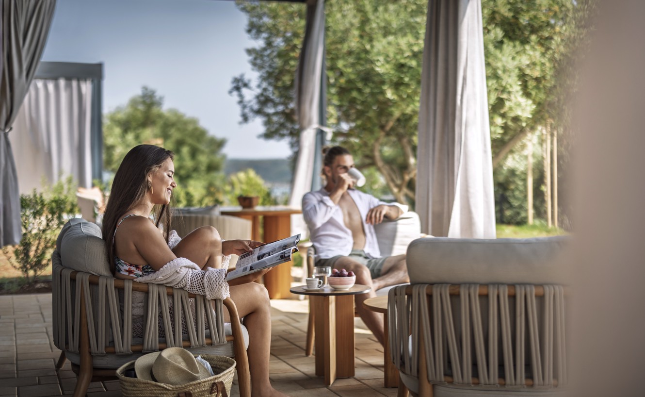Familie genießt einen ruhigen Morgen auf der Terrasse eines luxuriösen Ferienhauses mit Meerblick im Aminess Camping Sirena.