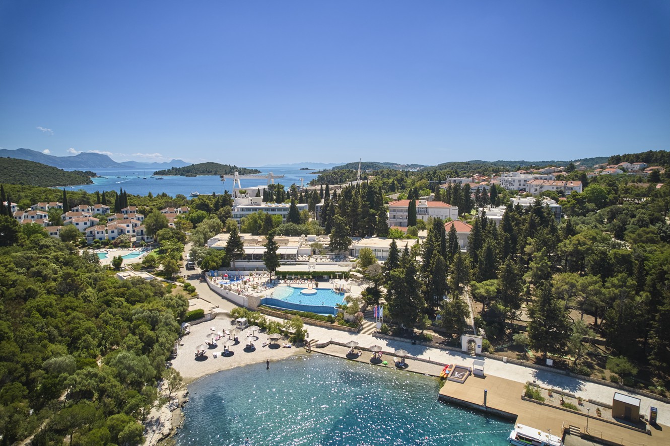 Exterior aerial view of Aminess Vival Port9 Resort, surrounded by greenery and the sea located in a bay on the island of Korcula.