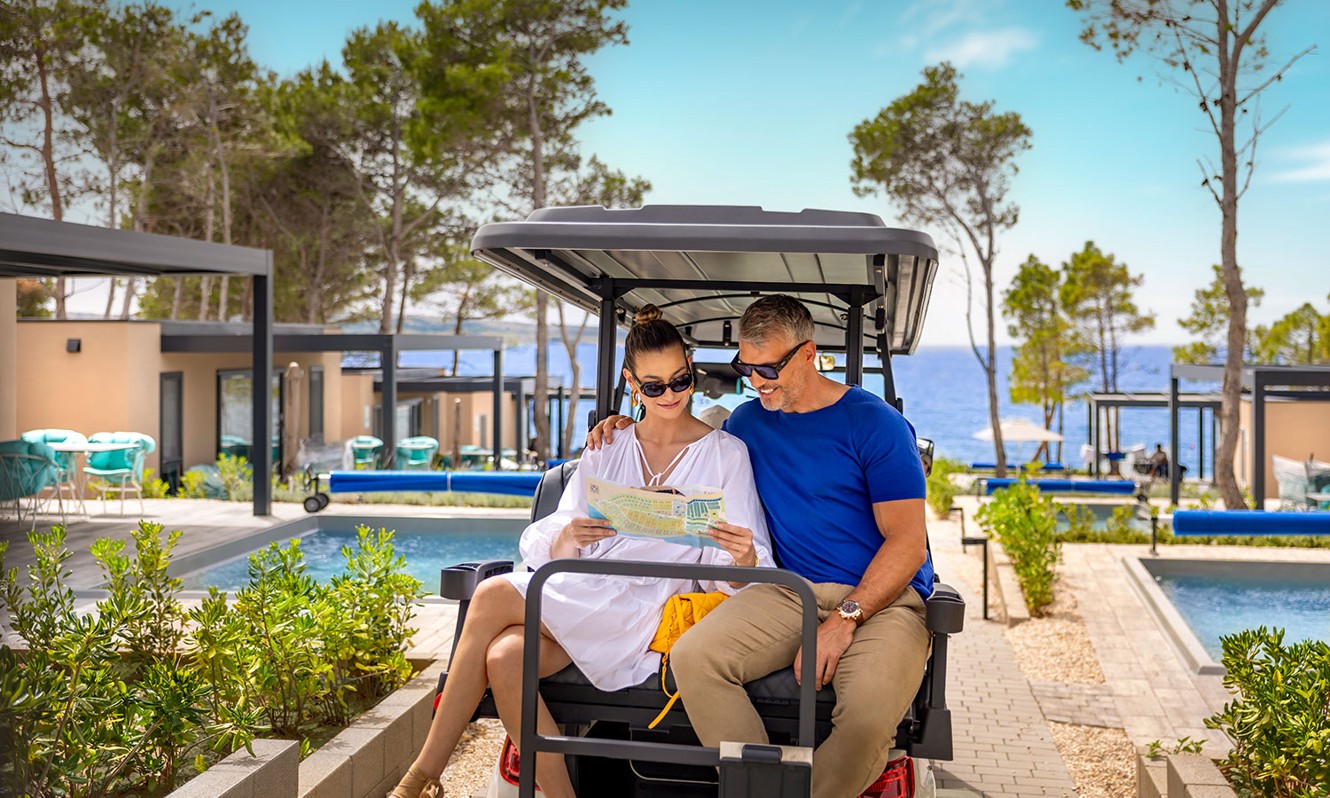 Coppia che guarda la mappa del campeggio e guida con papa mobile presso il resort Aminess Style Camping Avalona.