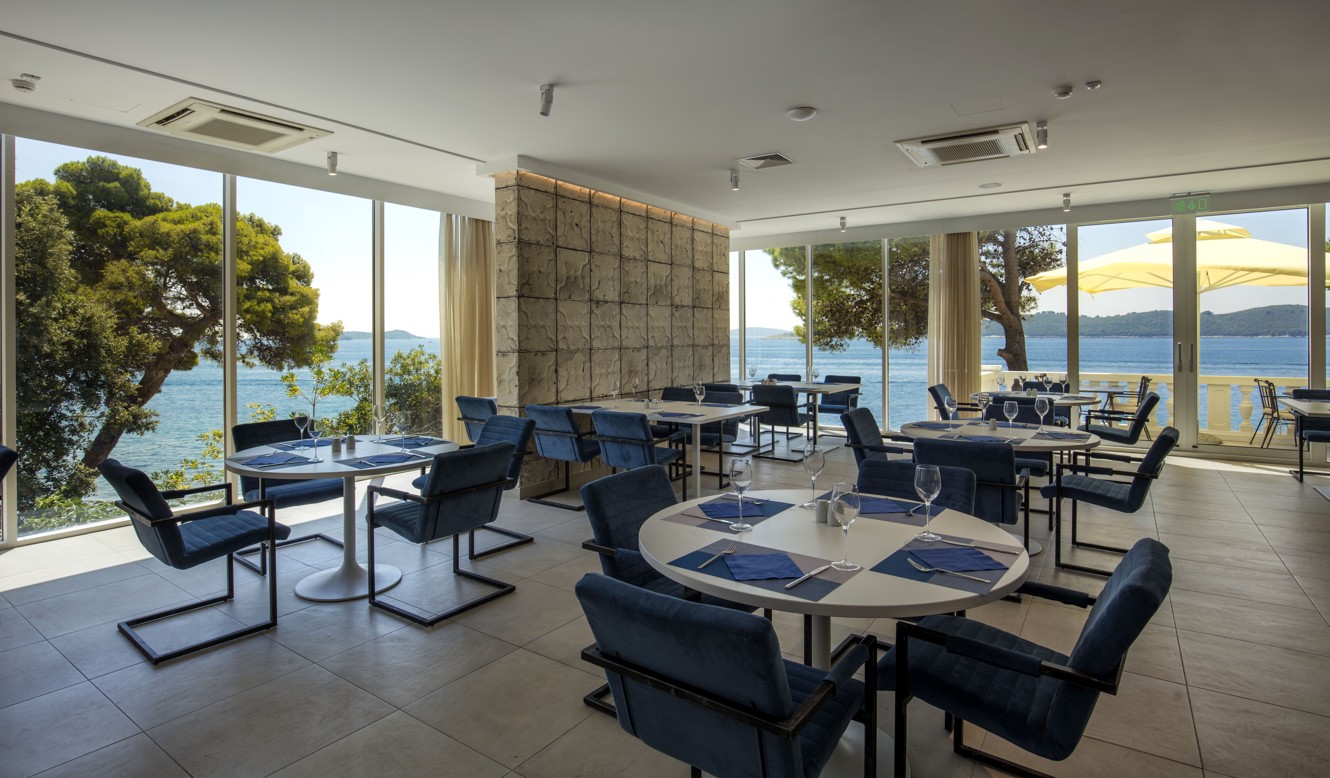 Pogled iznutra na buffet restoran u Aminess Bellevue Hotelu s prozorima od poda do stropa s pogledom na more.