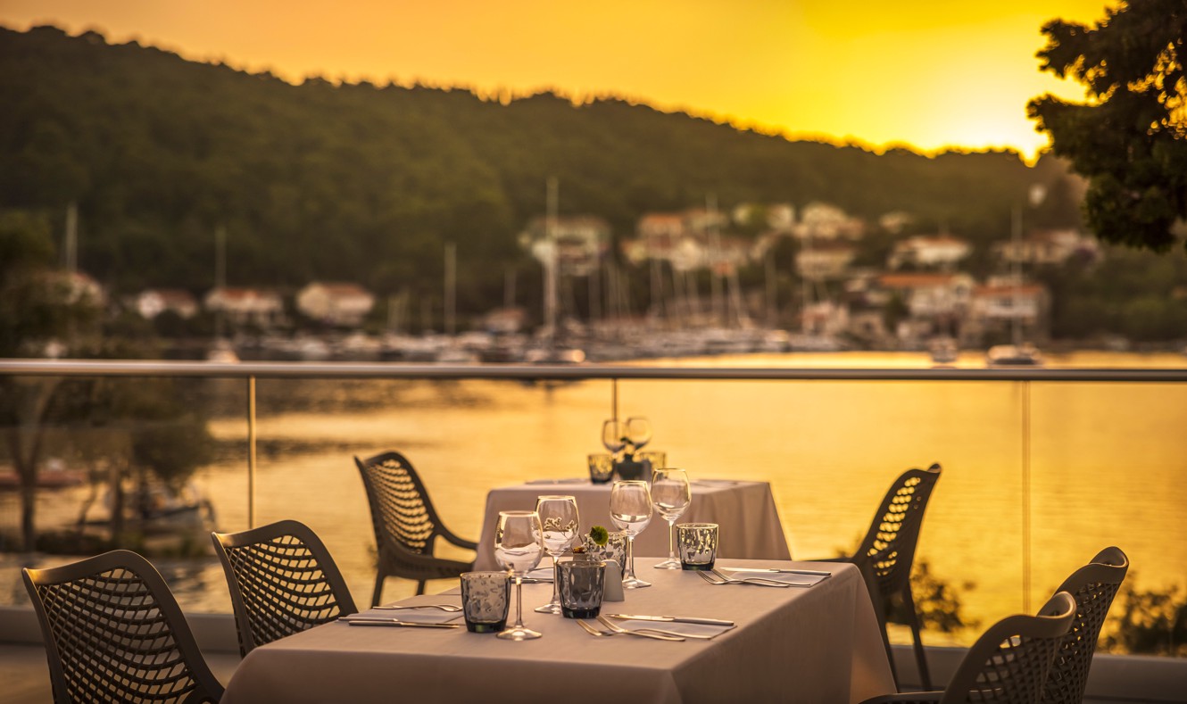 A table set for two on the terrace, with a stunning sunset view within the resort, near Port9 Planet Camping by Aminess.