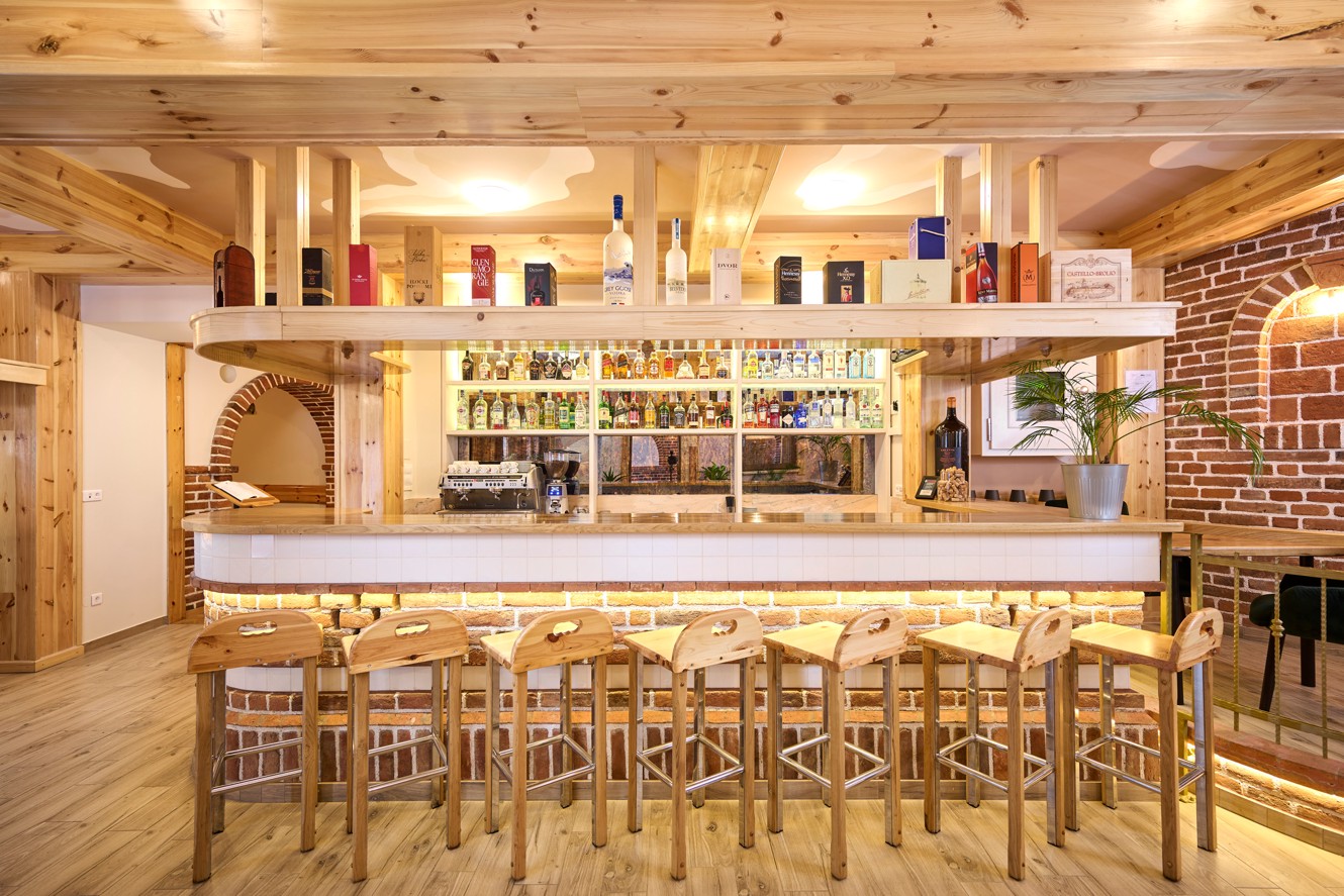 Bar dell hotel Aminess a Karlovac con dettagli in legno e selezione di bevande