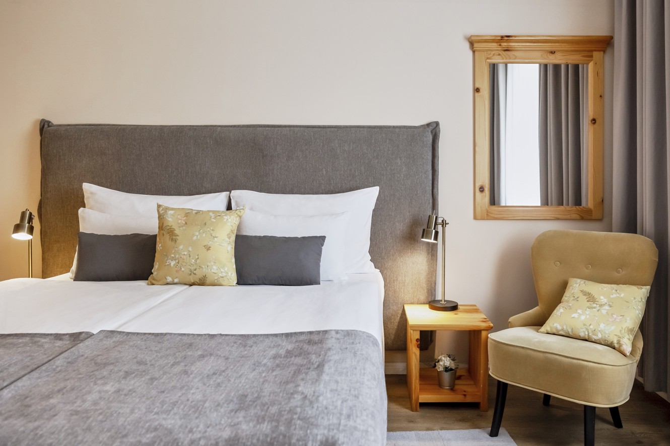 Camera da letto della suite dell hotel Aminess Karlovac con letto comodo e area salotto