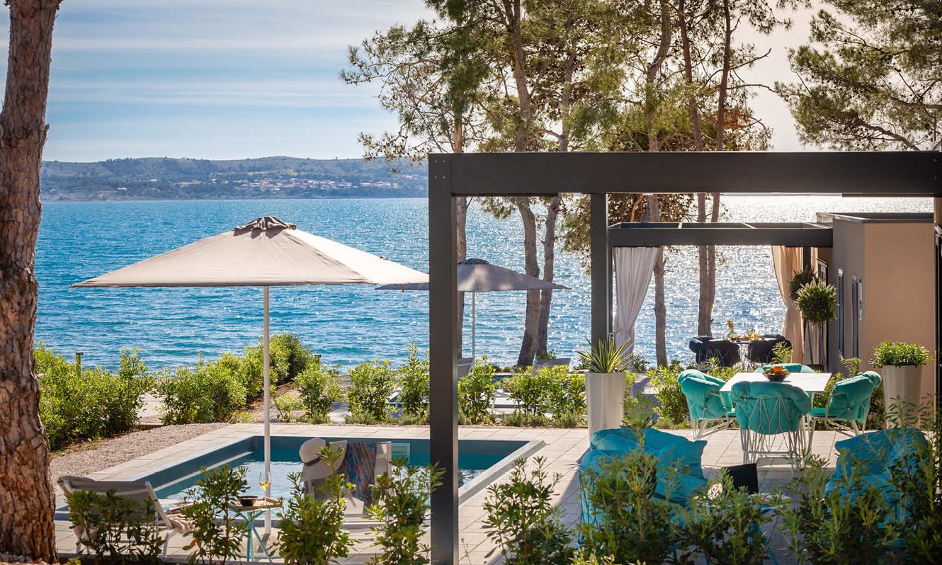 Vista della casa Holiday Home con piscina e parasole aperto sul mare presso il resort Aminess Style Camping Avalona.