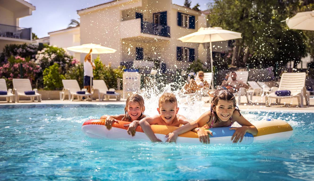 Family enjoying a fun day at the swimming pool at Aminess Vival Port9 Residence.