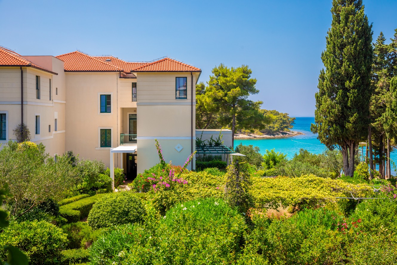 Exterior of Aminess Vival Velaris Resort on Brač island with a view of the Adriatic Sea and lush Mediterranean greenery