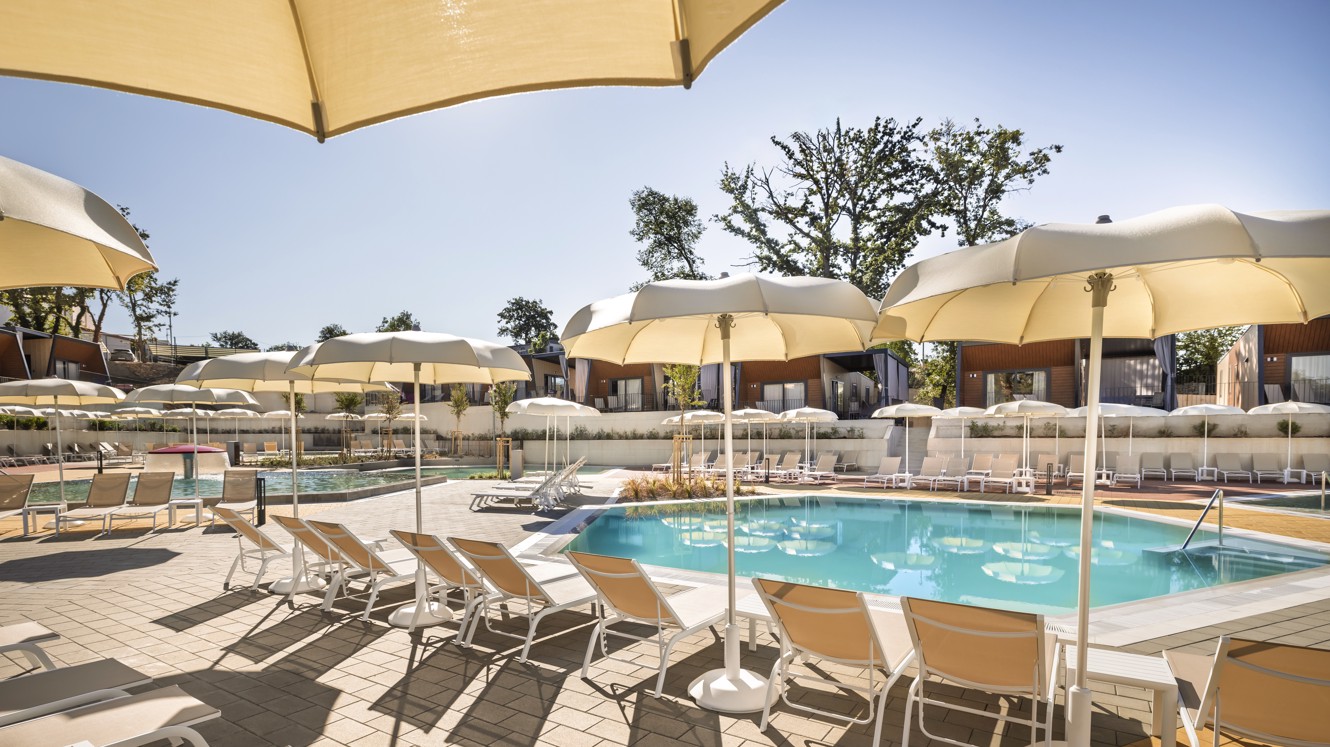 Kompleks bazenov s palmami in belimi ležalniki v kampu Aminess Atea na otoku Krku