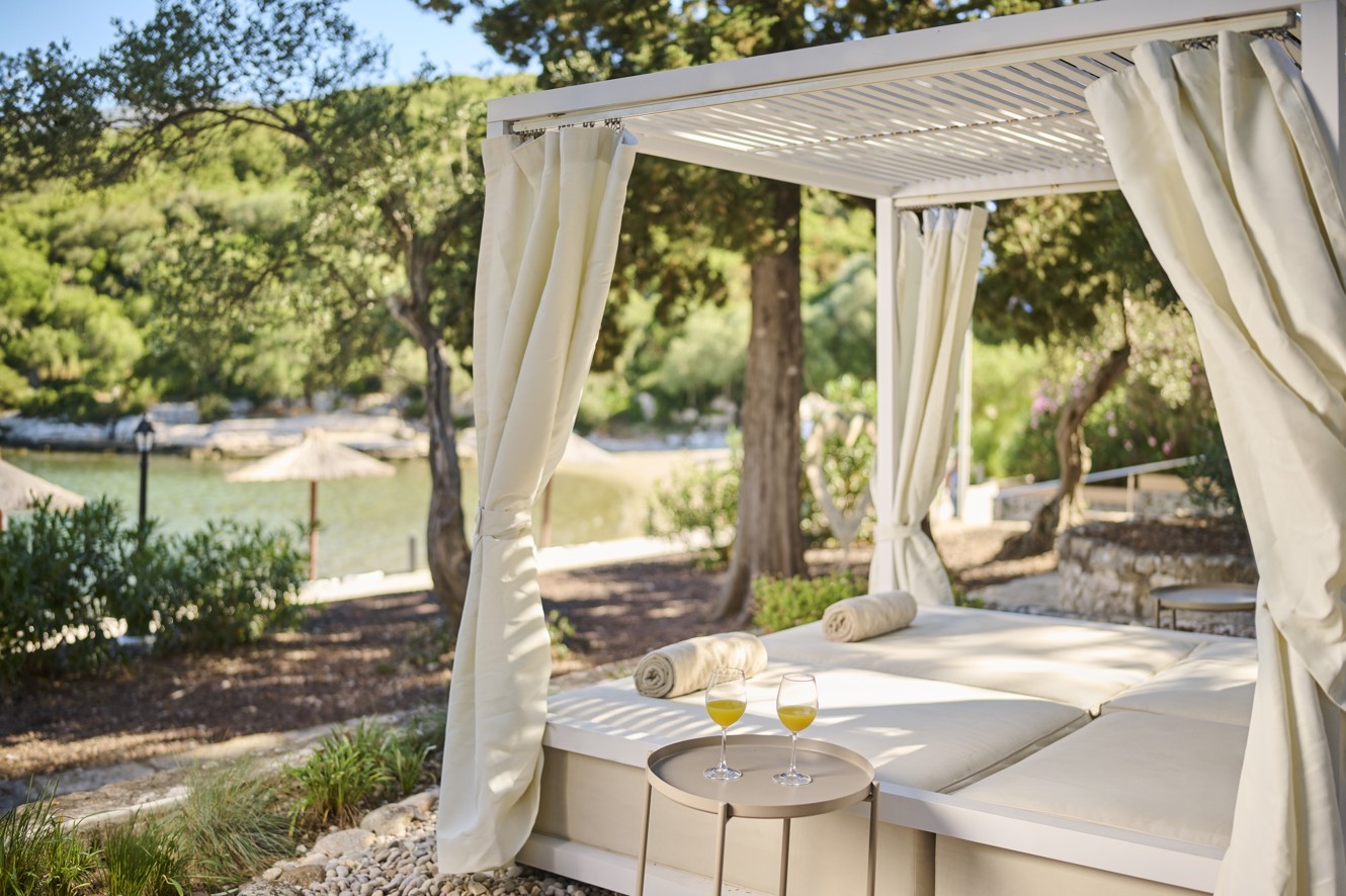 Beach canopy beds offering a relaxing retreat in natural shade within resort near Aminess Vival Port9 Residence in Croatia.