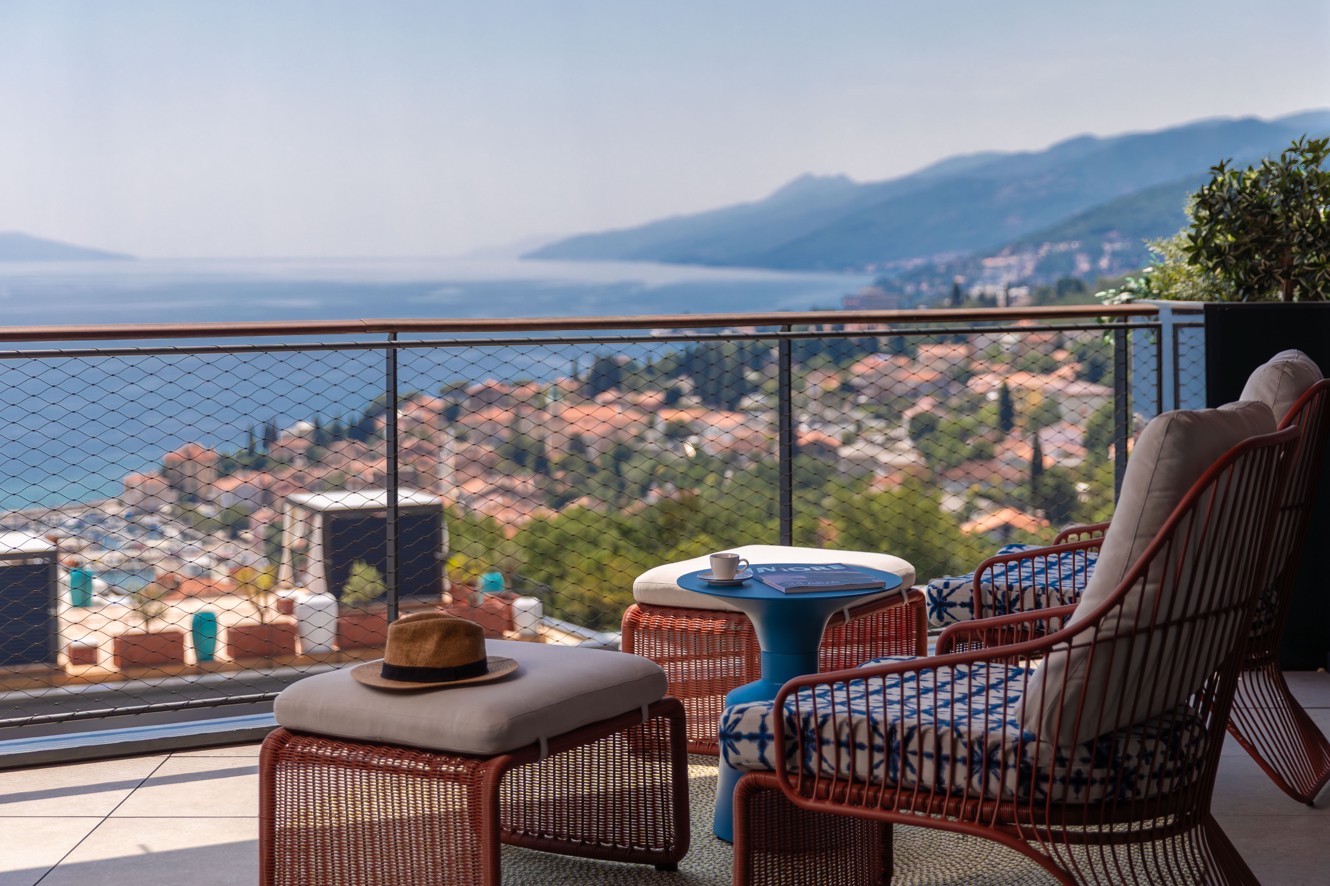 Terasa Aminess Vollo Residences s prostorom za sjedenje i pogledom na obalu.