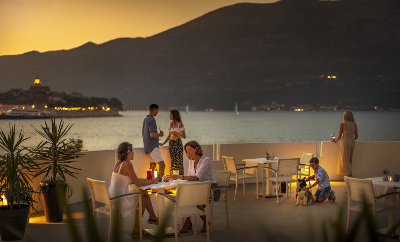 Gäste genießen die Sonnenuntergangsstimmung auf der Restaurantterrasse im Aminess Younique Liburna Hotel, Korcula.