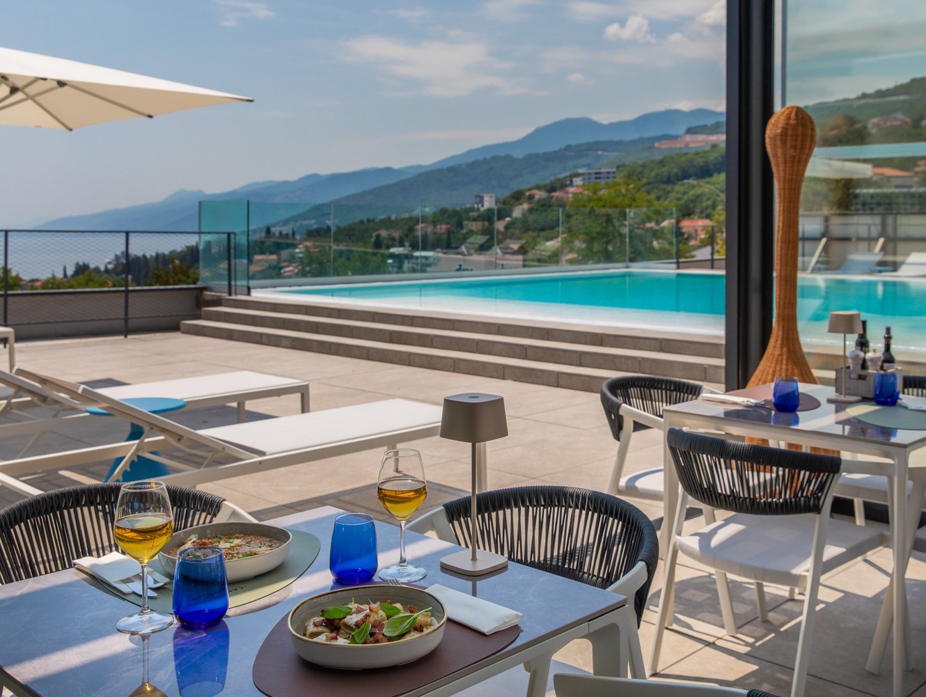 Terasa restorana Il Cantuccio uz bazen s jelima i pogledom na obalu.