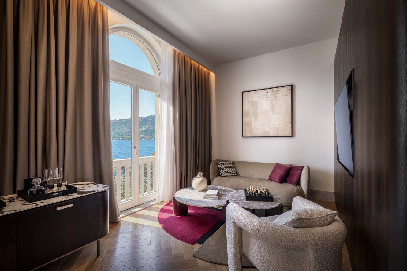 Modern Aminess hotel suite living room with a balcony and sea view.