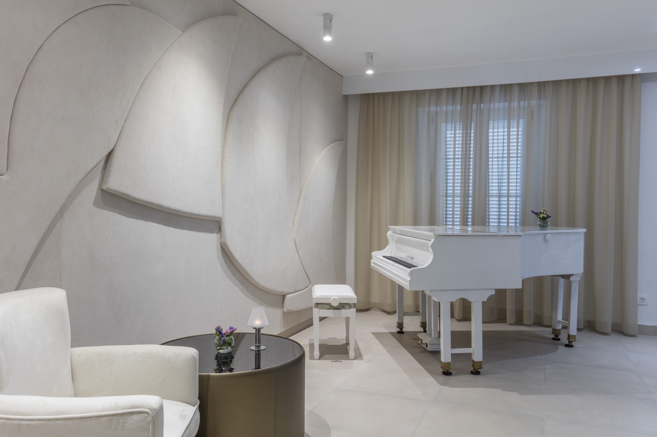 Piano bar v elegantni beli paleti znotraj hotela blizu Aminess Maradiso Casa Bellevue.