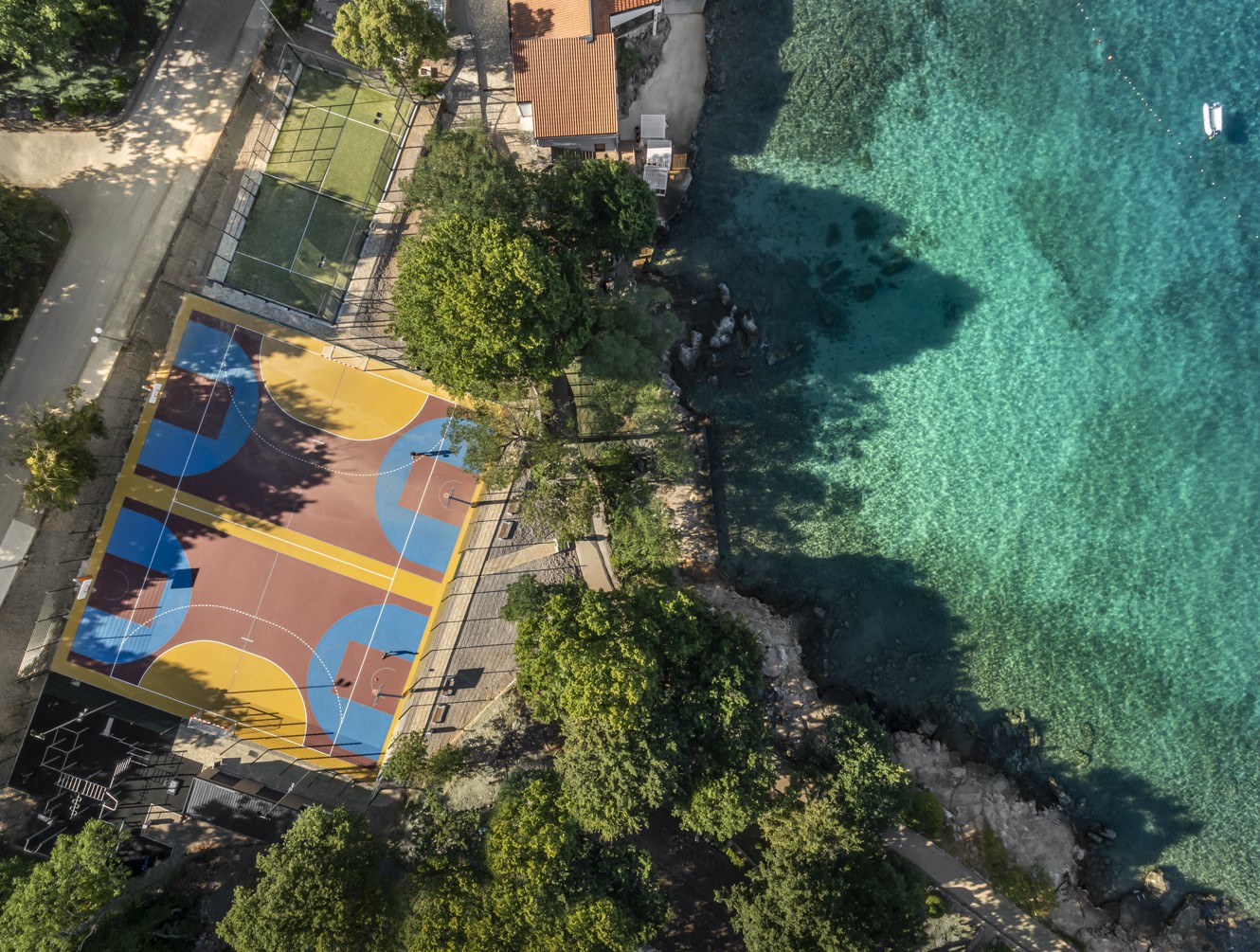 Sportska zona s teniskim terenom i zelenim okruženjem u Aminess Style Camping Atea Resort.