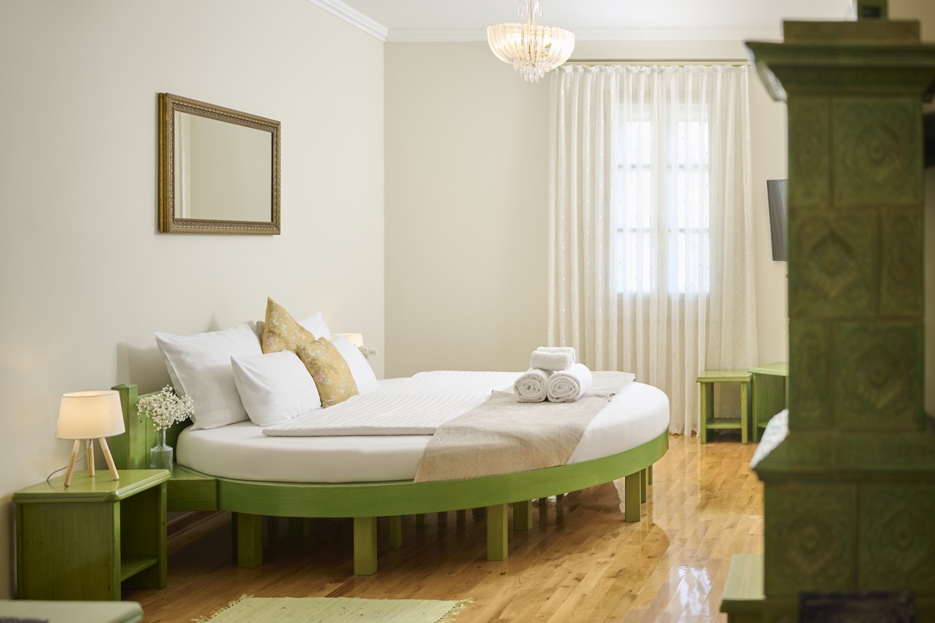 Camera king dell hotel Aminess Karlovac con letto rotondo e mobili verdi