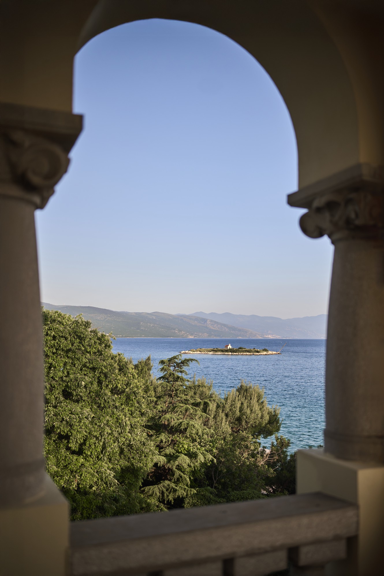Romantičen balkon s kamnitim lokom in pogledom na morje in otoček pri hotelu Aminess Lišanj.