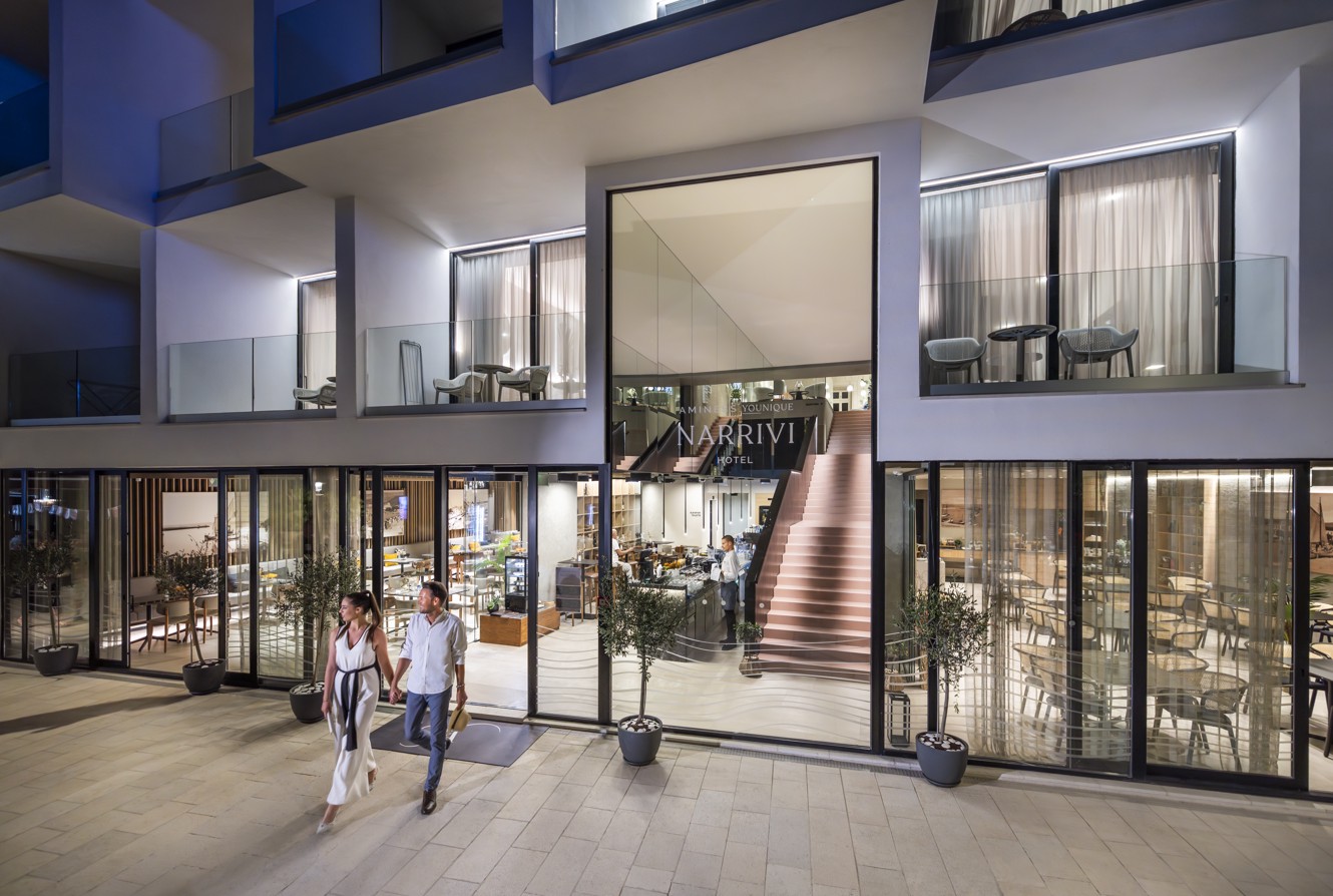 Night view of the modern exterior of Aminess Younique Narrivi Hotel.