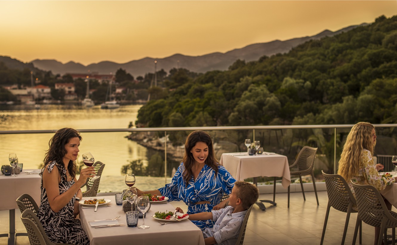 Guests enjoying a meal on the restaurant terrace, with a stunning view of the sunset within resort near Aminess Vival Port9 Residence.