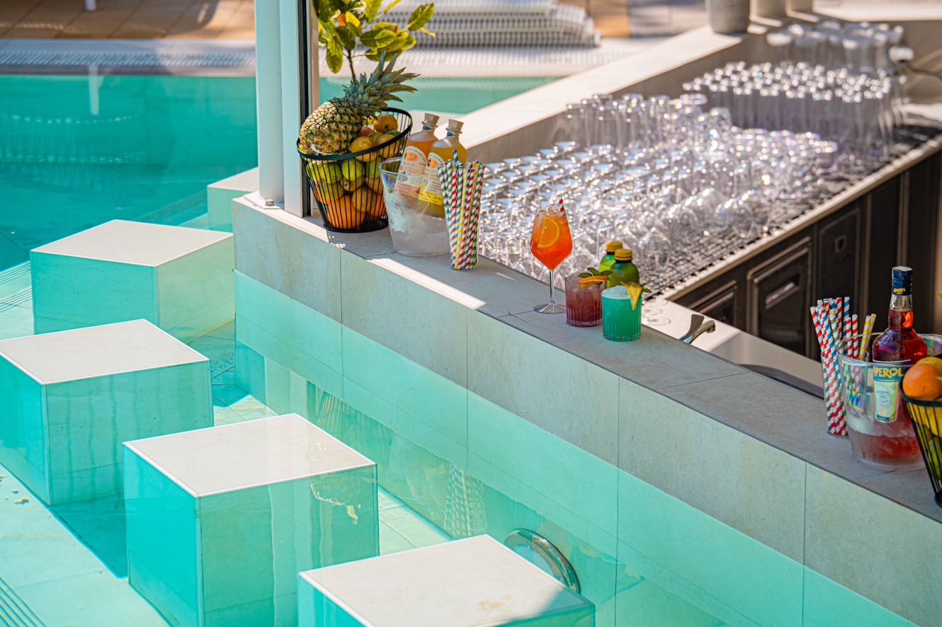 Bazenski bar s potopljenimi sedeži, tropskimi koktajli in kozarci v Aminess Style Camping Atea Resortu.