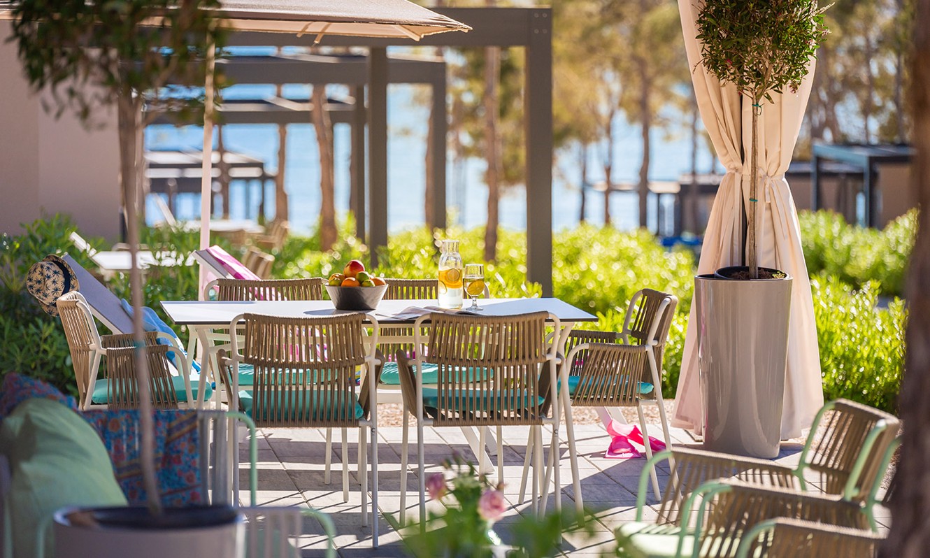 Vista dal balcone di fronte alla Holiday Home con fiori e area salotto presso il resort Aminess Style Camping Avalona.