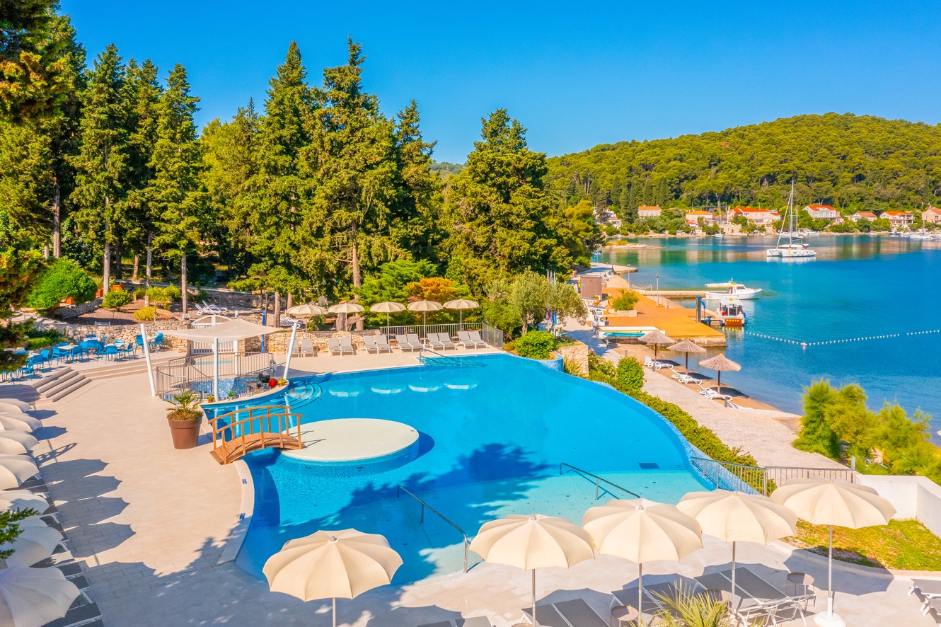 Sunlit pool by the beach at the Aminess Vival Port9 Resort.