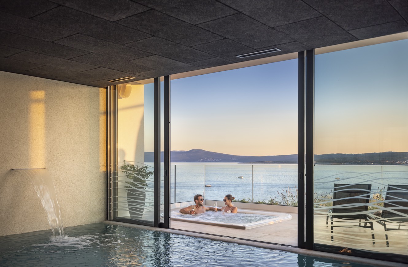 Couple relaxing in a jacuzzi with a sea view at the wellness center of Aminess Younique Narrivi Hotel in Crikvenica.