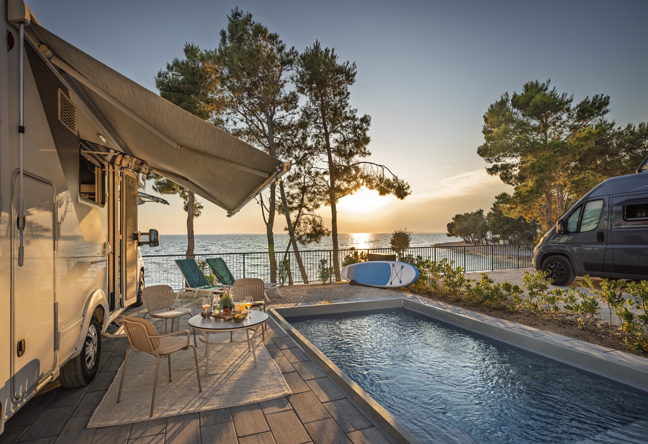 Camper vehicle parked next to the pool on mega luxury mare pitch in Aminess Style Camping Avalona resort.