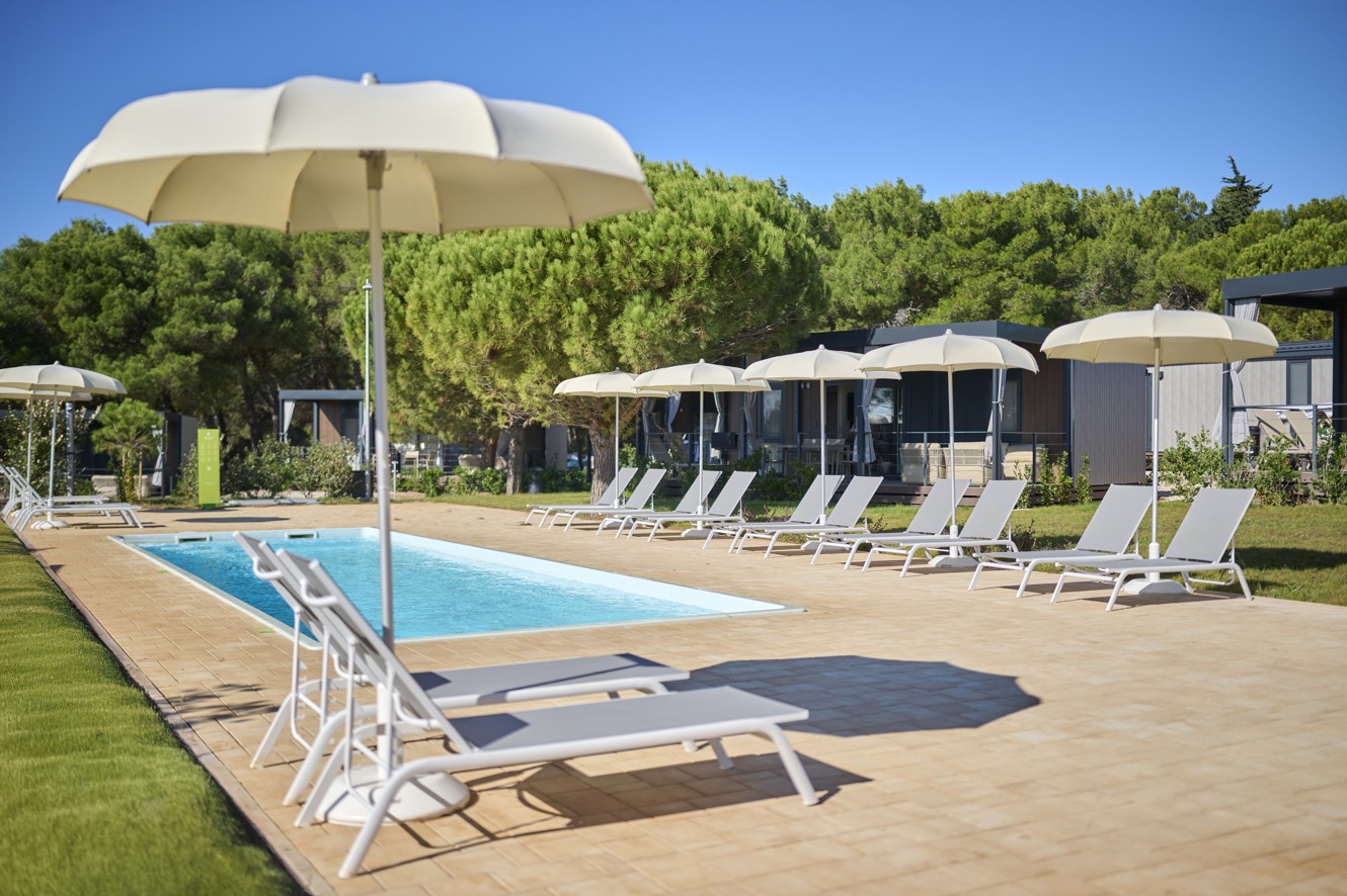 Bazen i ležaljke ispred Premium Holiday Home u Aminess Planet Camping Sirena Holiday Homes, idealno mjesto za opuštanje i sunčanje