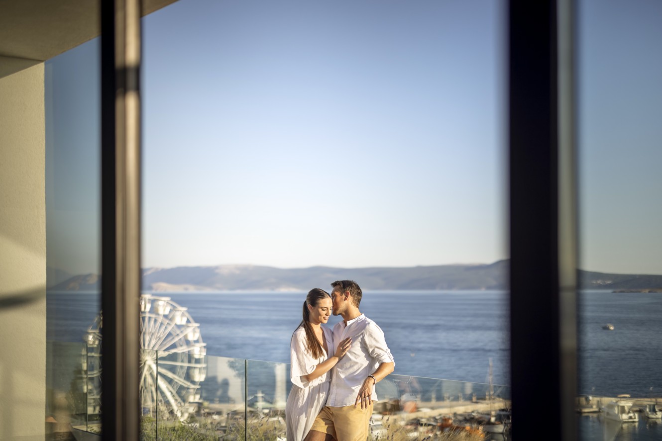 Romantic couple enjoying the view from the wellness terrace at Aminess Younique Narrivi Hotel.