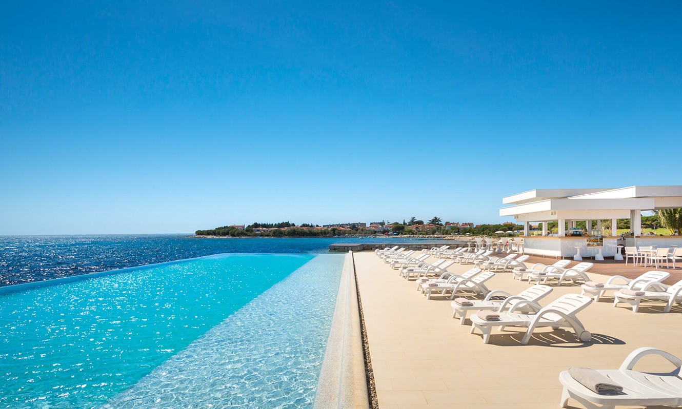 Piscina Punto Mare con lettini prendisole presso l'Aminess Maradiso Hotel Laguna, Novigrad