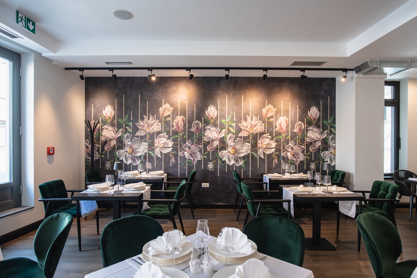 Hotel restaurant interior with floral wall and elegant dining tables