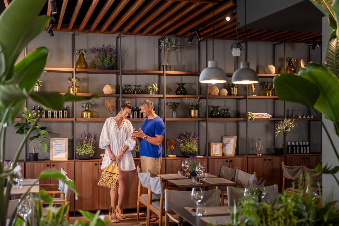 Paar im Loop Restaurant auf der Suche nach Wein im Aminess Style Camping Avalona Resort.