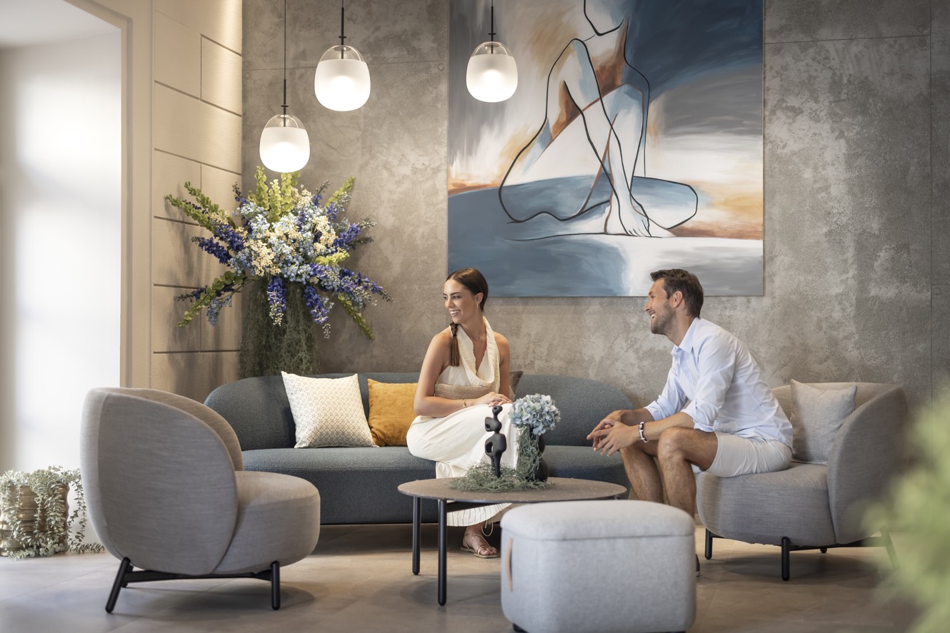 Couple seated at the reception area of Aminess Younique Narrivi Hotel.