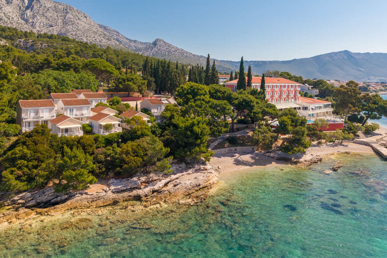 Bellevue Maradiso Village by Aminess by the sea, with villas, greenery and mountains.