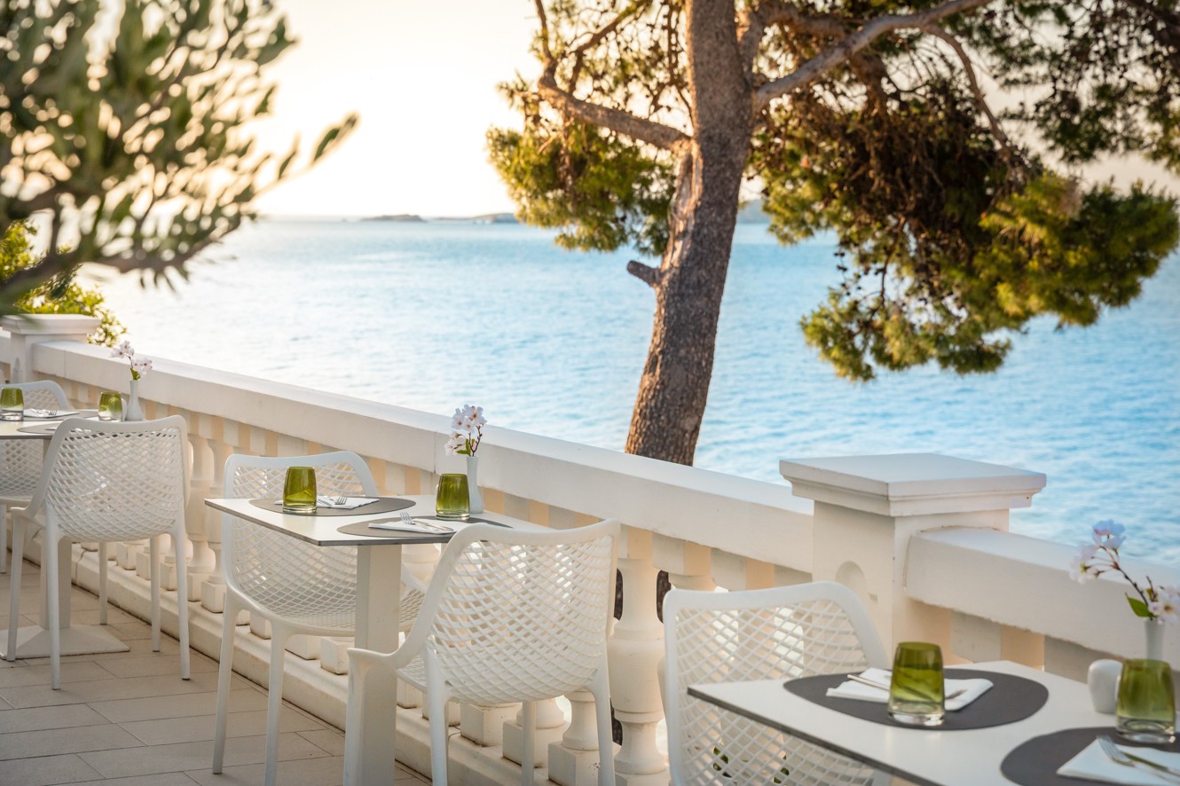 Restaurant terrace at Younique Bellevue Hotel with a sea view.
