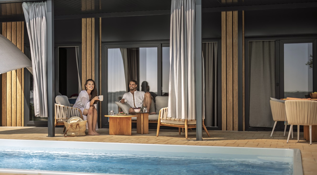 Paar entspannt am Abend auf einer privaten Terrasse mit Pool in einem luxuriösen Ferienhaus im Aminess Camping Sirena.