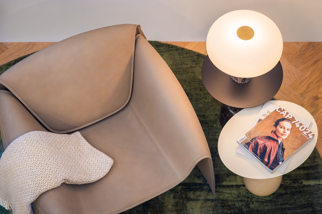 Cozy luxury duplex suite corner with an armchair, lamp and magazines