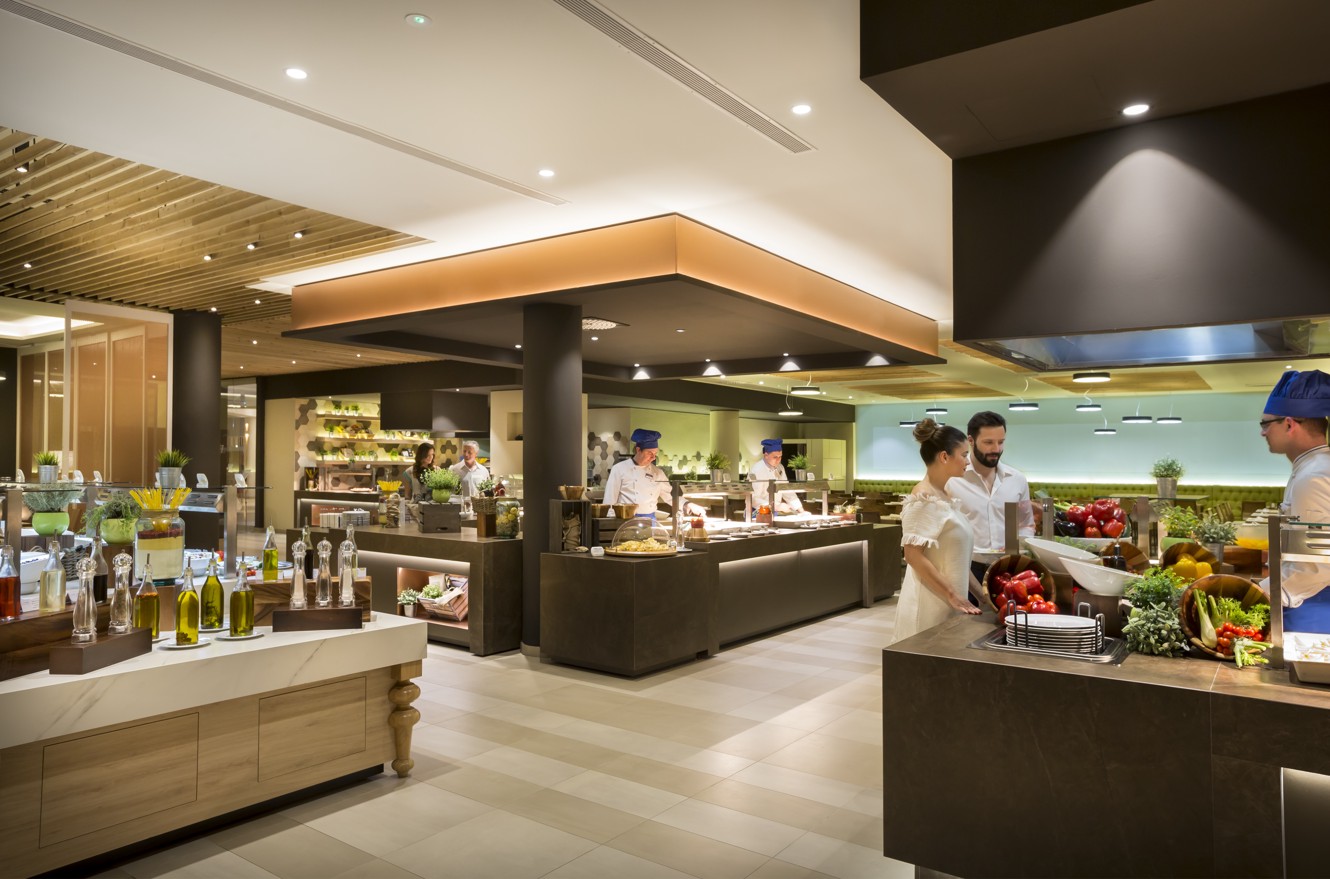 Ristorante a buffet presso l'Aminess Vival Hotel Maestral con ospiti che scelgono i loro pasti e una varietà di opzioni alimentari.