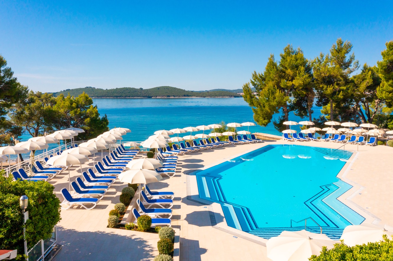 Stunning seaside view of the pool area surrounded by natural beauty at Aminess Vival Grand Azur Hotel.