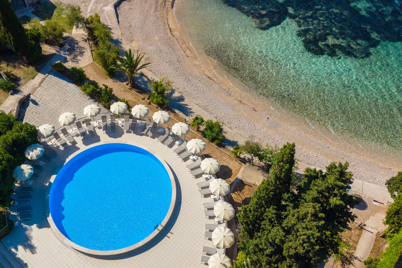 Aerial view of the pool at Orsan Maradiso Hotel by Aminess beside the beach and clear sea.