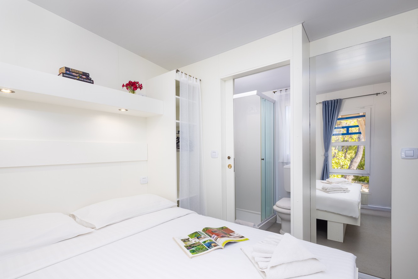 Slaapkamer met tweepersoonsbed en privébadkamer in de Marko Polo Holiday Home, Port9 Planet Camping by Aminess op het eiland Korčula.