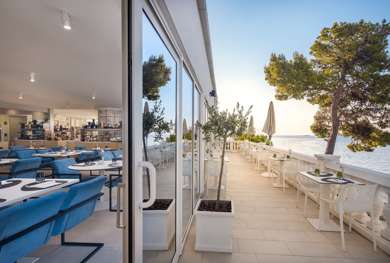 Unico restaurant at Younique Bellevue Hotel opens onto a terrace with a sea view.