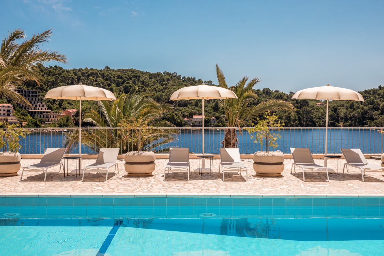 Relaxing by the pool in front of Aminess Younique Lume Hotel, the perfect spot to enjoy peace, comfort, and premium hotel service.