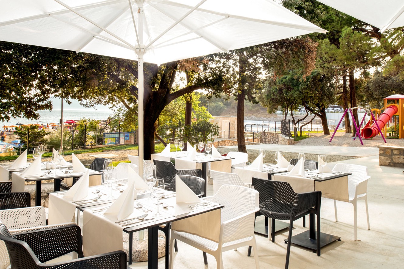 Aminess Vival Lišanj Family Hotel terrazza del ristorante all'aperto con posti a sedere ombreggiati, circondati da verde e un'atmosfera adatta alle famiglie a Novi Vinodolski.