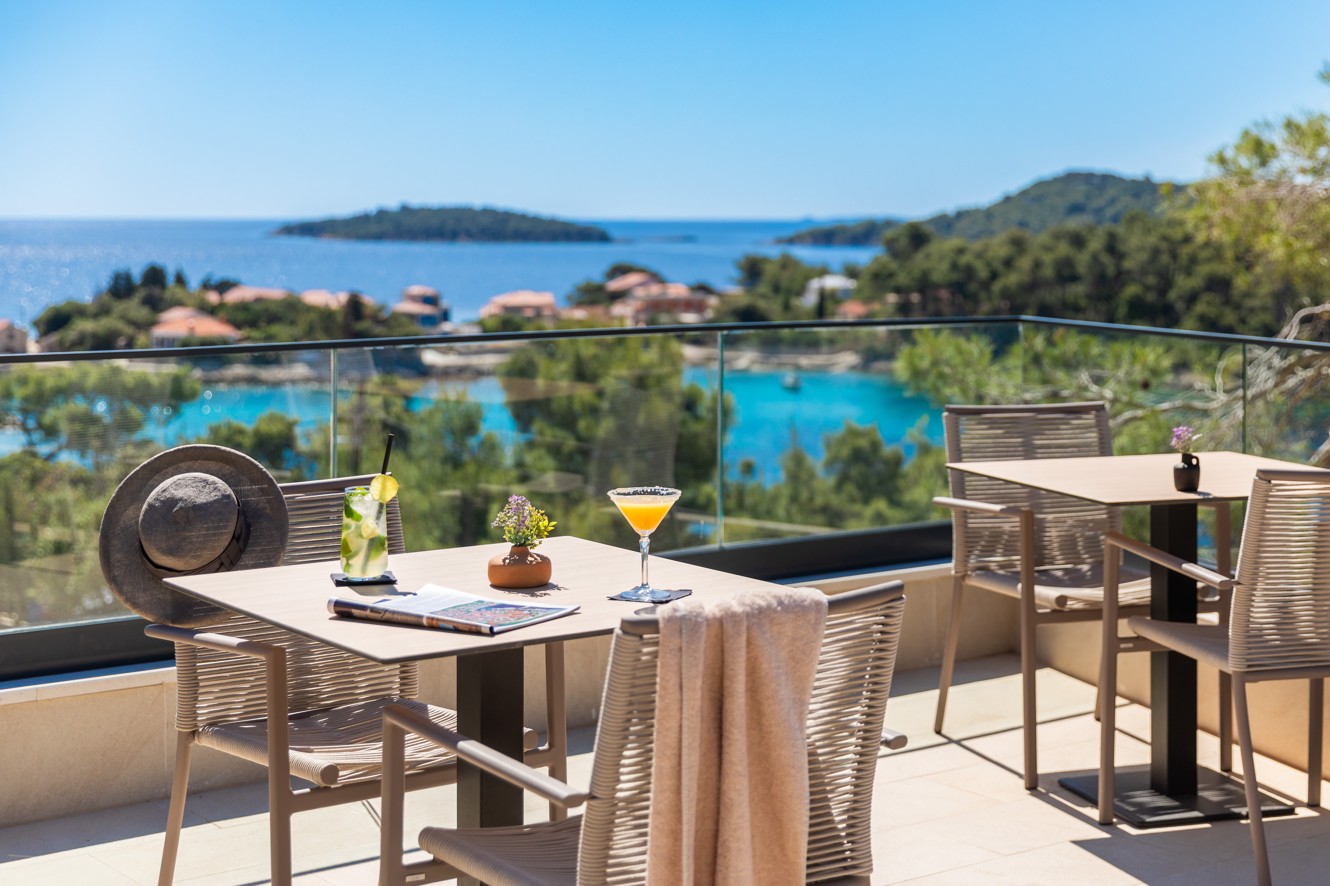 Poolbarterras van Aminess Alfir Hotel met cocktails en uitzicht op zee.